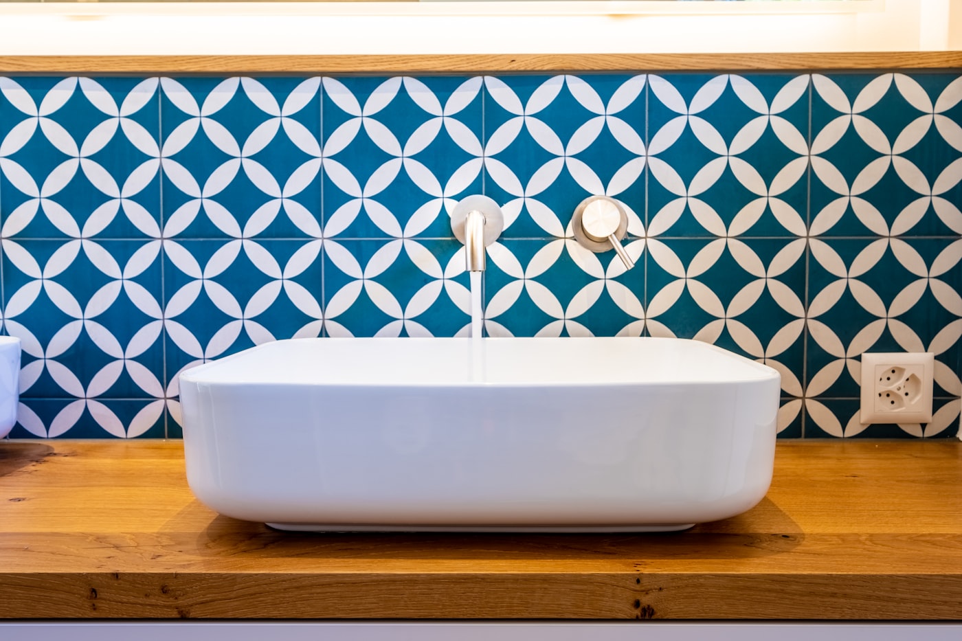 Badezimmer mit blau-weiß gefliester Wand und Badewanne