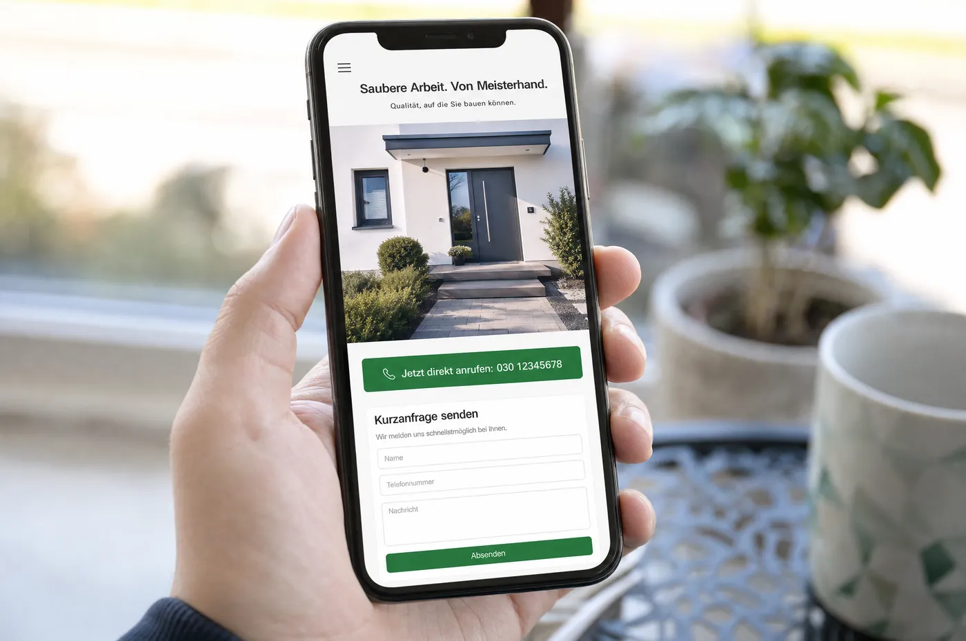 Smartphone mit einer Handwerker-Website: Foto einer fertigen Arbeit, darunter eine breite Schaltfläche zum Anrufen und ein kurzes Anfrageformular